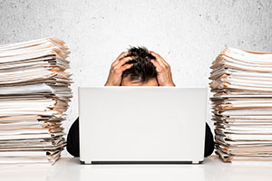 Photo of worker at desk surrounded by paper